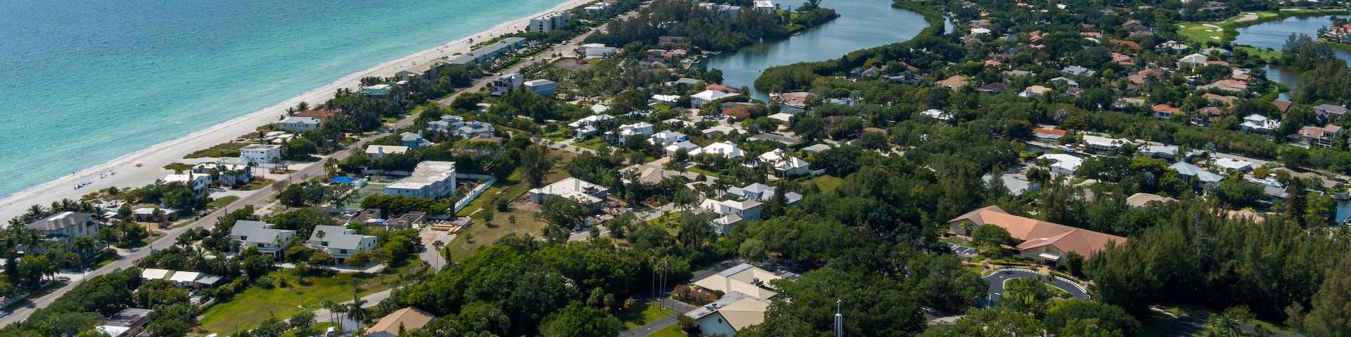 A coastal town with a beach, residential areas, and a marina.