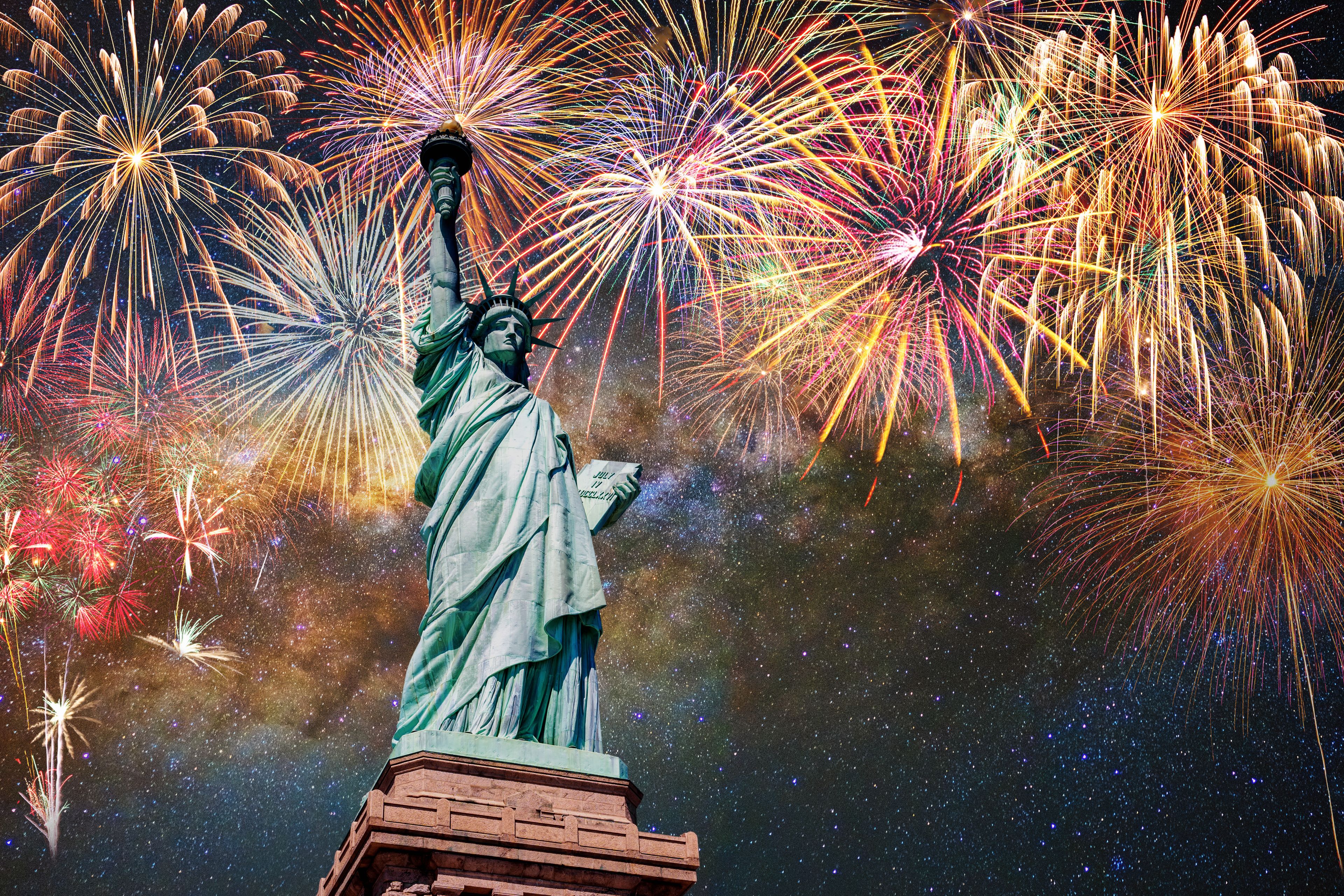 The Statue of Liberty with fireworks in the background.