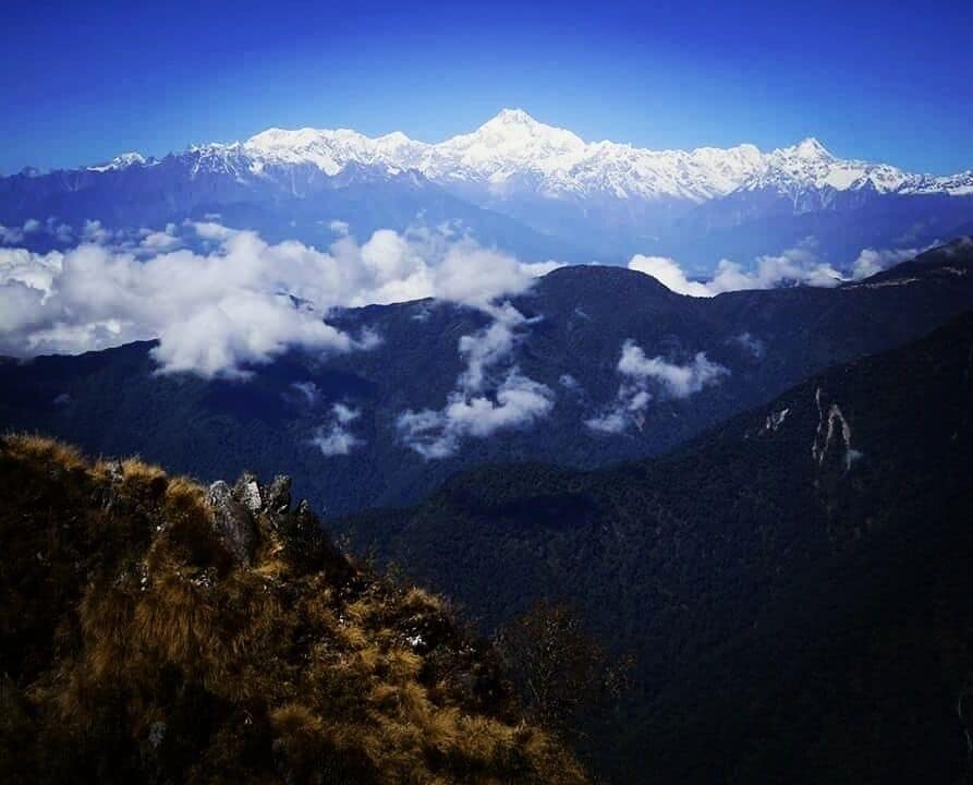 A mountain range with snow-capped peaks and a valley below.