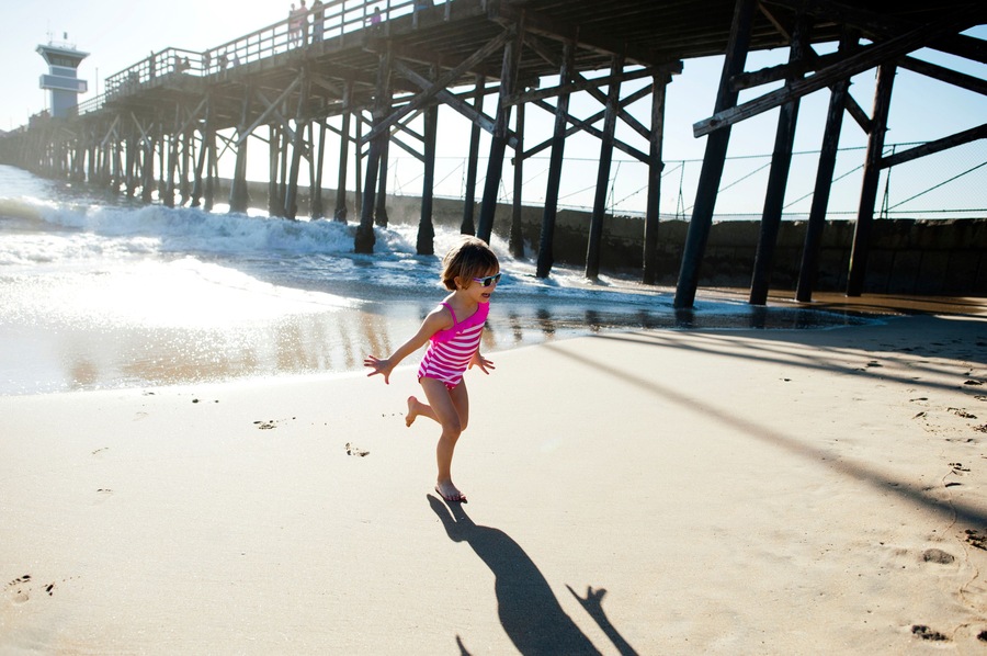 Full length of girl running on shore at Seal Beach