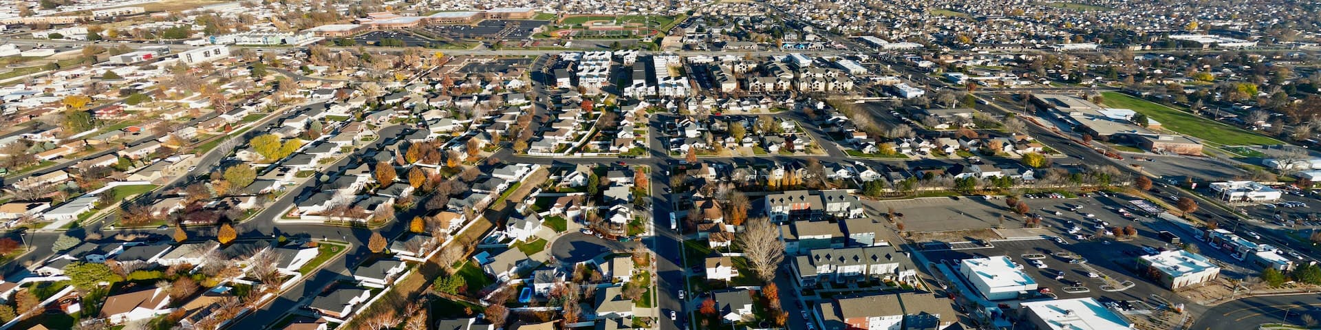 Aerial view of a symmetrical layout of residential houses and streets contrasting with the distant snow-capped mountains, Layton, Utah, United States.
