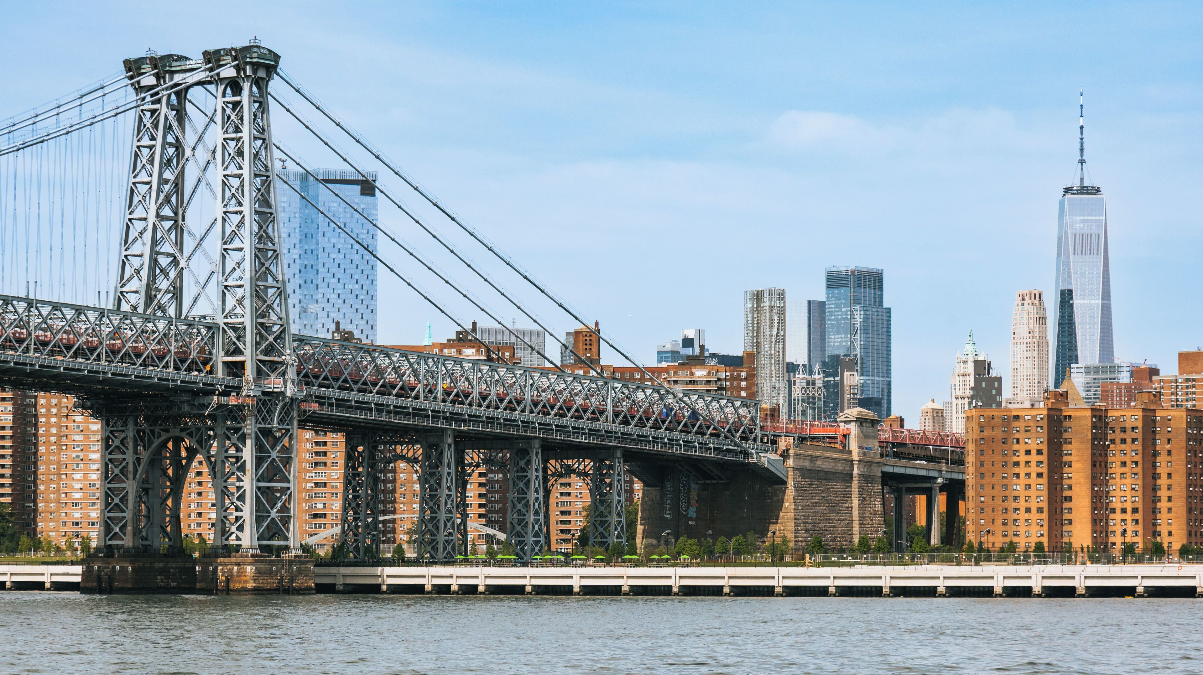 A suspension bridge with a city skyline in the background.