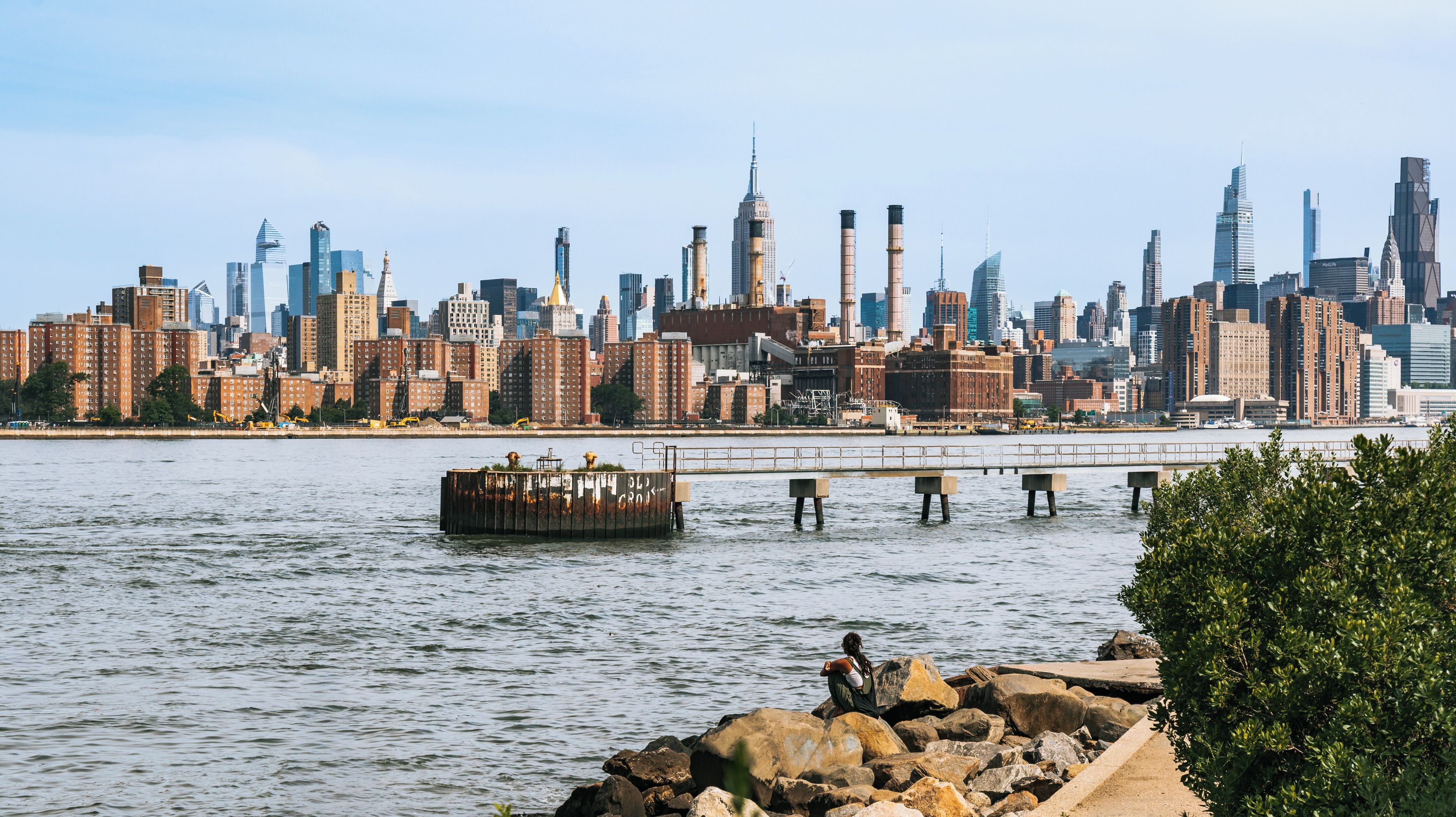 A river with a bridge and a city skyline in the background.