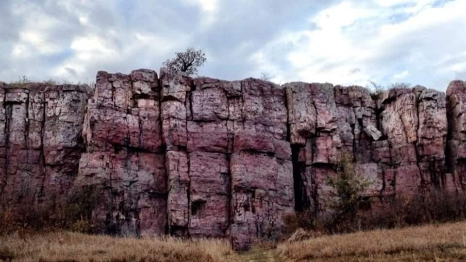 A rocky cliff formation with sparse vegetation.