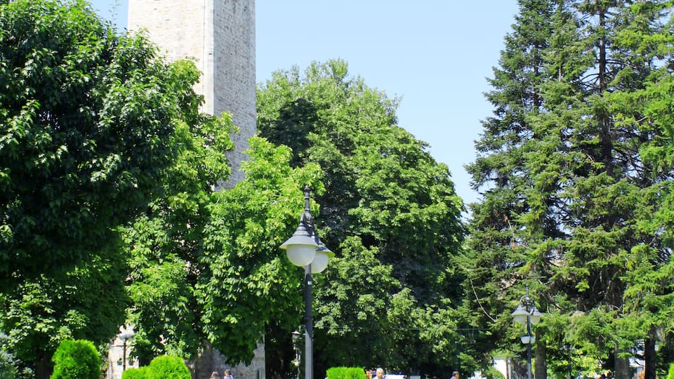 A park with a clock tower, benches, and walking paths.