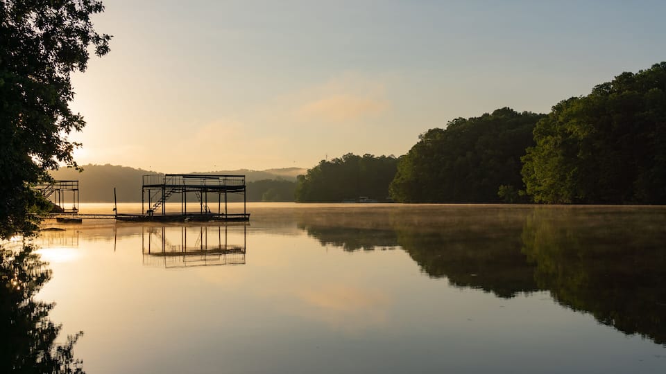 Fog on Lake Lanier in Georgia at sunrise with the silhouette of a dock