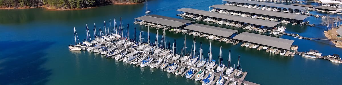 aerial shot of the boats and yachts docked in the marina on the waters of Lake Lanier surrounded by lush green trees with powerful clouds at sunset in Buford Georgia USA