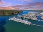 aerial shot of the boats and yachts docked in the marina on the waters of Lake Lanier surrounded by lush green trees with powerful clouds at sunset in Buford Georgia USA