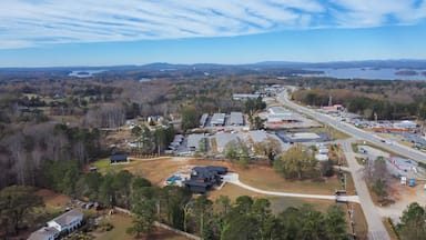 Aerial view Lanier Island Parkway with farm ranch style residential houses, commercial buildings and huge Lake Lanier in background cloud blue sky Buford, USA