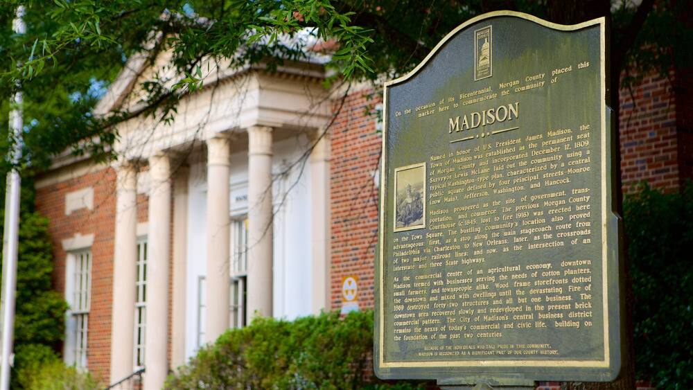 Une plaque commémorative devant un bâtiment en briques orné de colonnes.