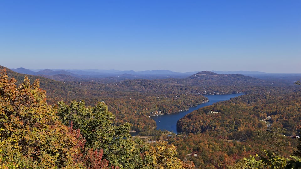 A river winding through a forested valley with distant mountains.