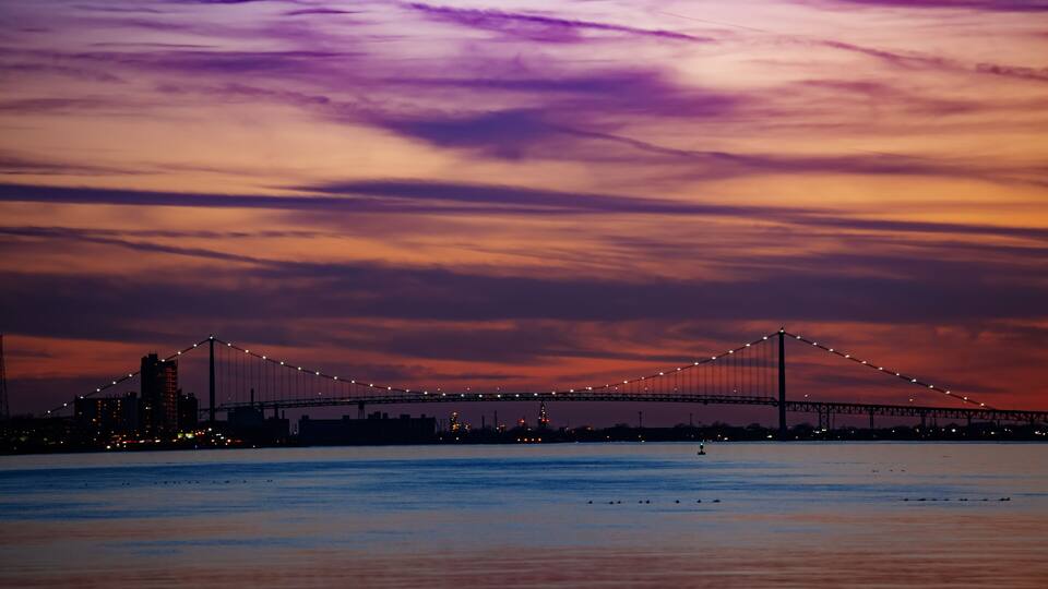 A bridge at dusk with a purple sky.