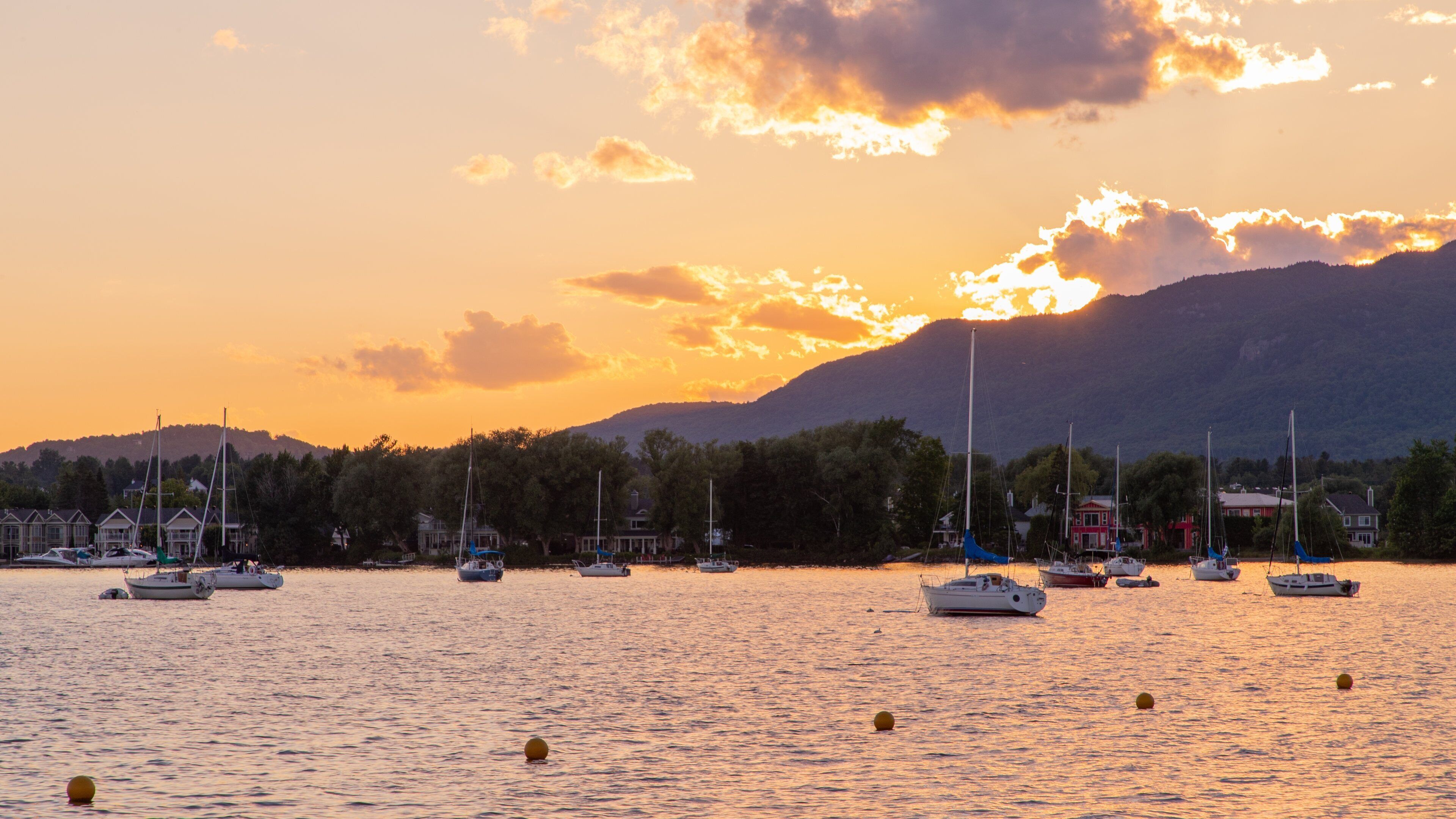 Magog which includes a bay or harbor and a sunset