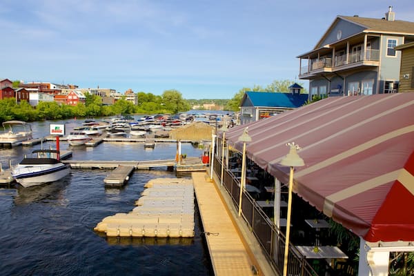 A marina with boats docked, a wooden dock, and a restaurant with a striped awning.
