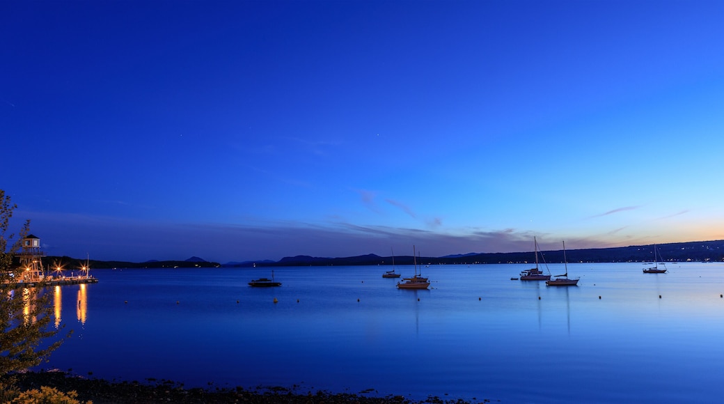 Observatory tower at sunset or sunrise on Memphremagog lake in Magog. Canadian beautiful landscape with mountains, lake, boats, night sky and awesome water reflections.