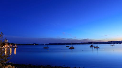 Observatory tower at sunset or sunrise on Memphremagog lake in Magog. Canadian beautiful landscape with mountains, lake, boats, night sky and awesome water reflections.