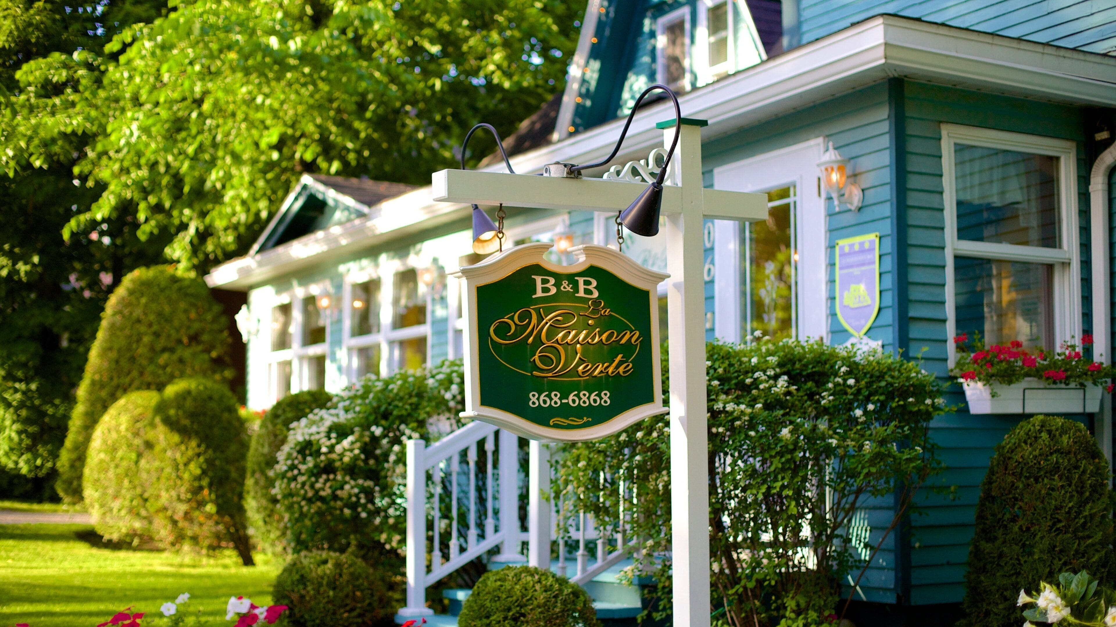 A house with a sign reading "B&B La Maison Verte" and a phone number.