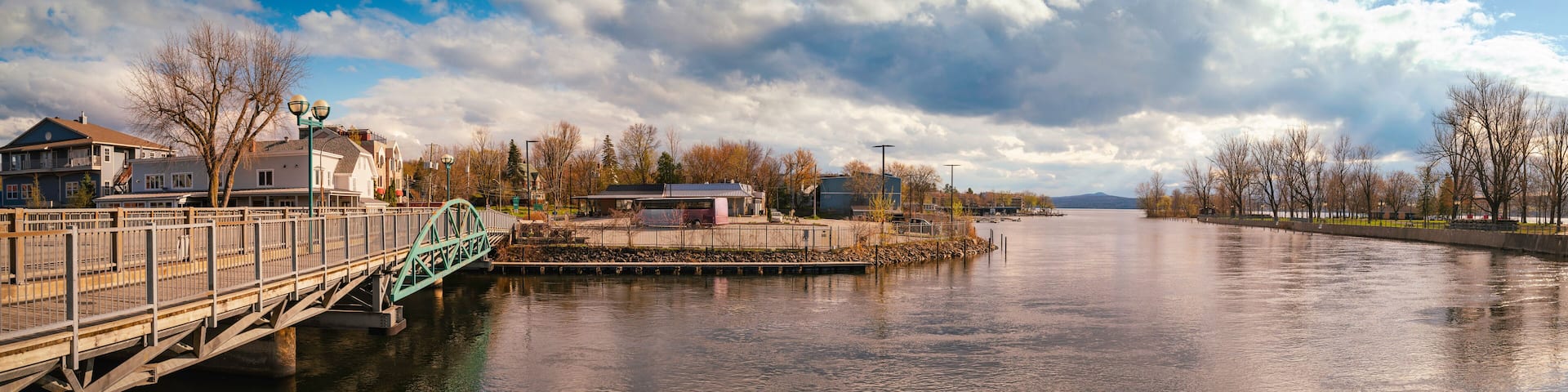 A river with a bridge, buildings, and trees.