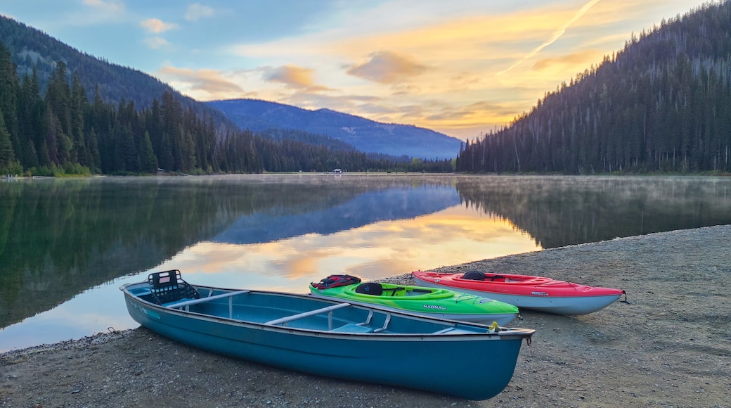 Peaceful morning at Lightning Lake with canoes on the shore and mountain reflections, Manning Park, Canada