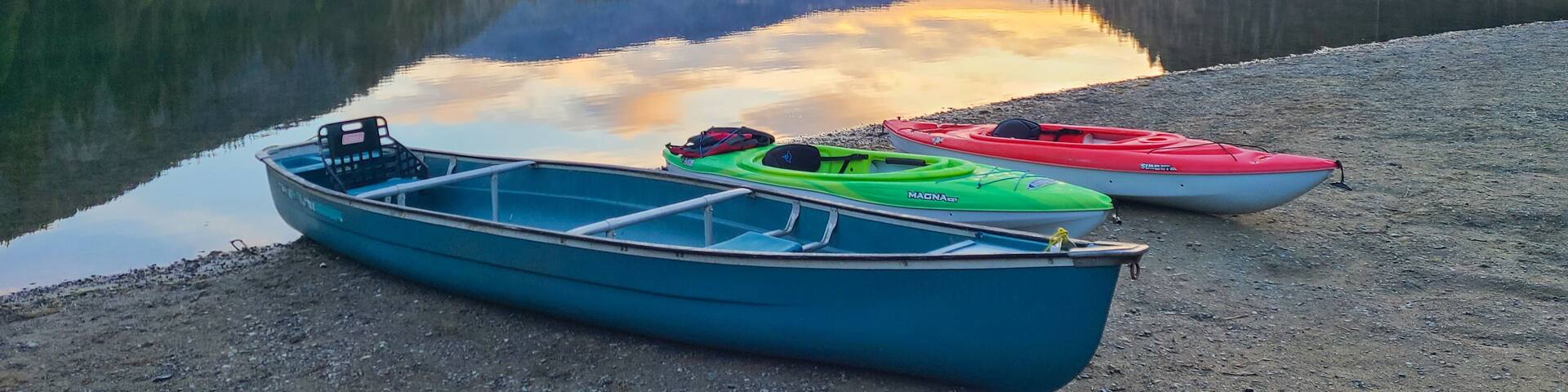 Peaceful morning at Lightning Lake with canoes on the shore and mountain reflections, Manning Park, Canada