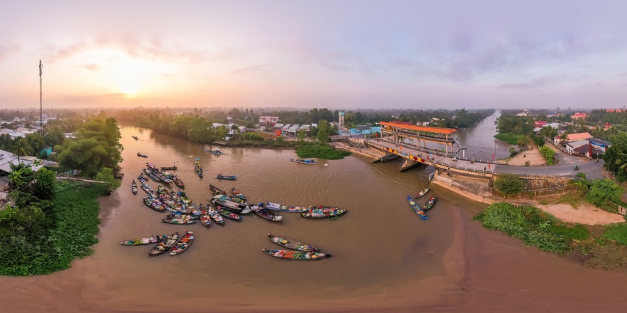 A river with boats docked on the left and a bridge on the right.