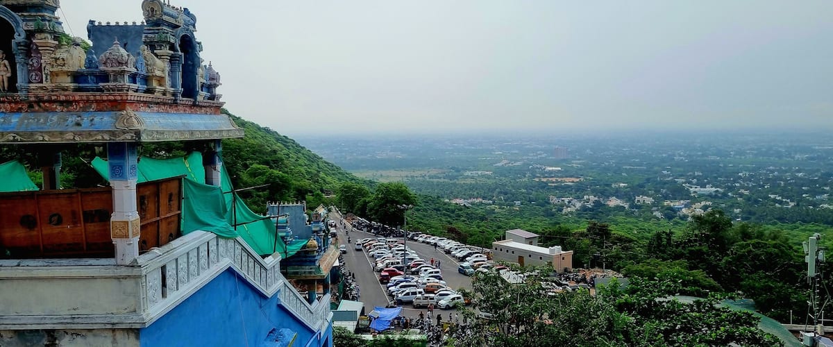 A temple with intricate architecture on a hill overlooking a city.