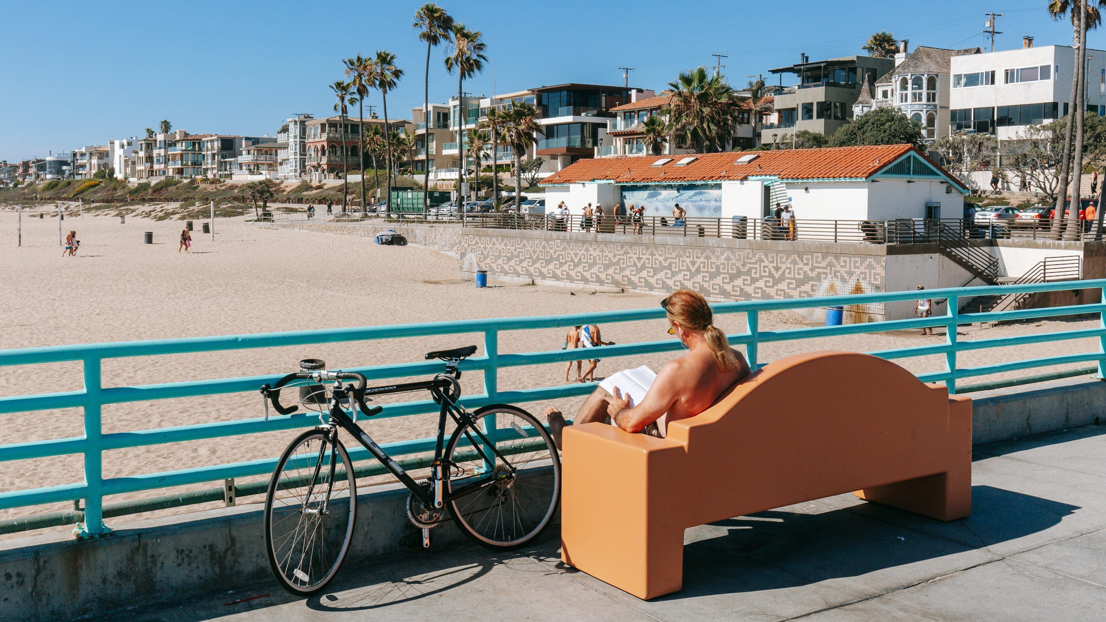 Manhattan Beach which includes a sandy beach and a coastal town as well as an individual male