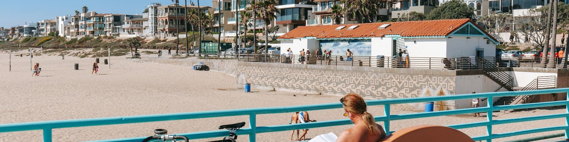 Manhattan Beach which includes a sandy beach and a coastal town as well as an individual male