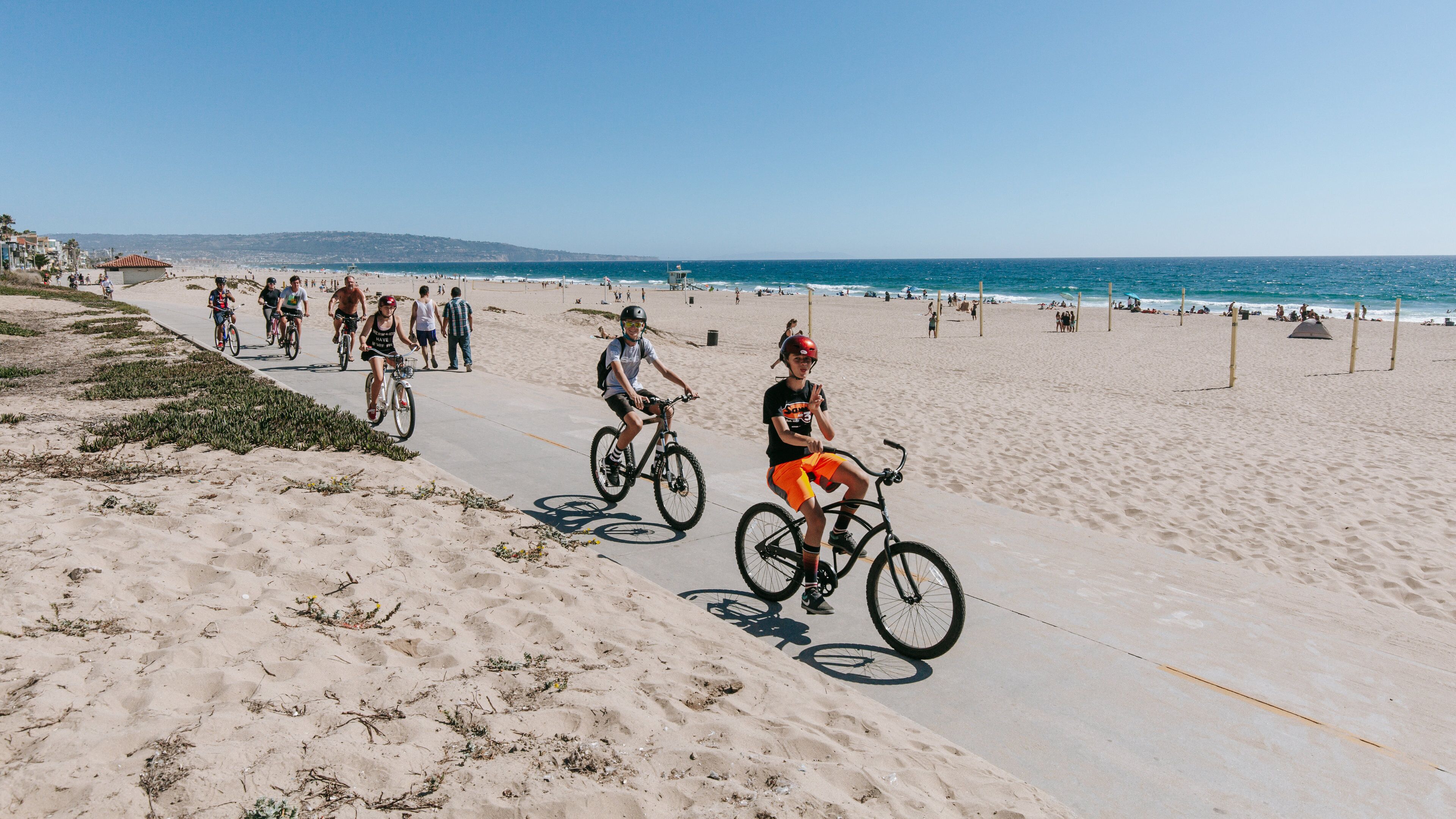 Manhattan Beach featuring a sandy beach and cycling as well as a small group of people