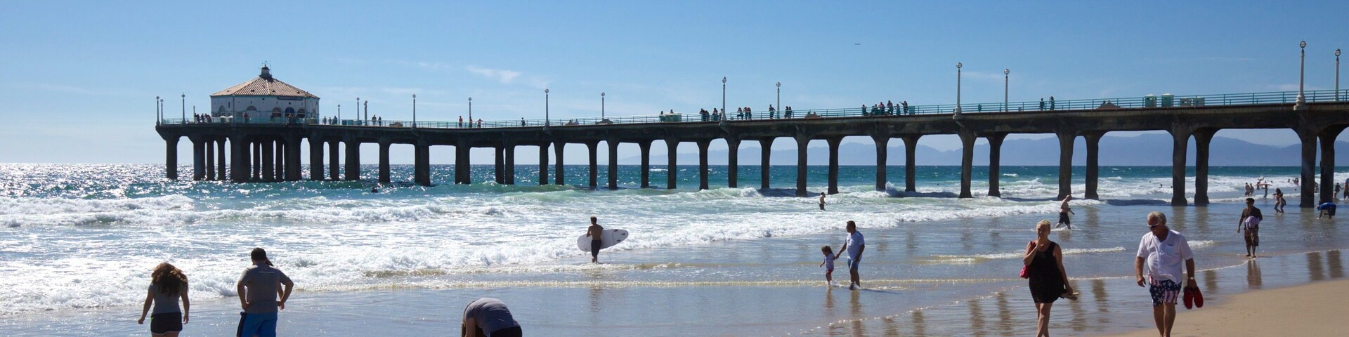 Manhattan Beach mostrando uma praia de areia e escalada ou caminhada assim como um pequeno grupo de pessoas