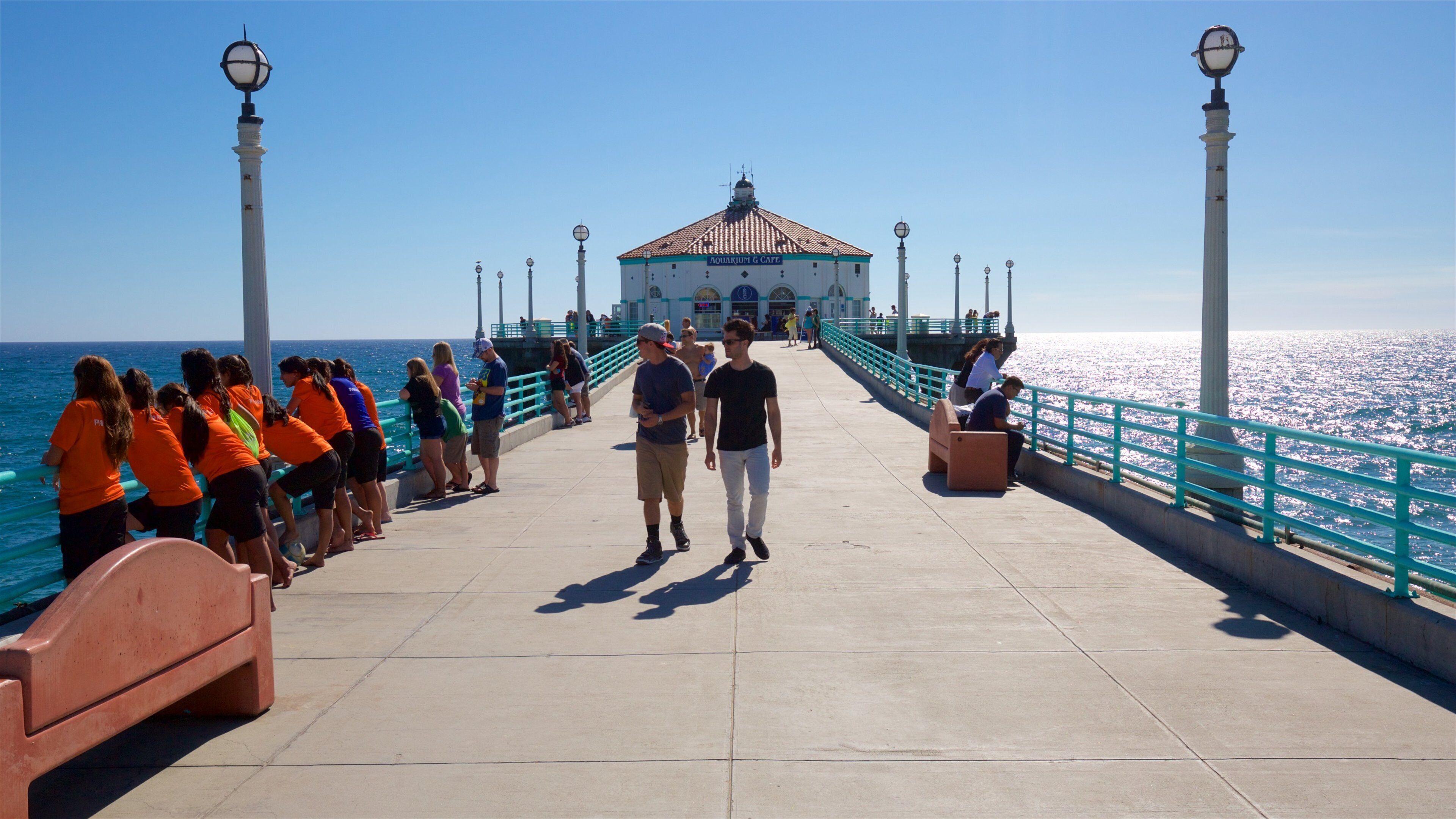 A pier with people, a cafe, and the ocean.