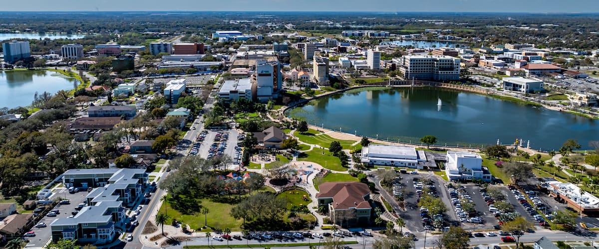 Une vue urbaine comprenant un vaste plan d’eau, un parc et divers bâtiments.