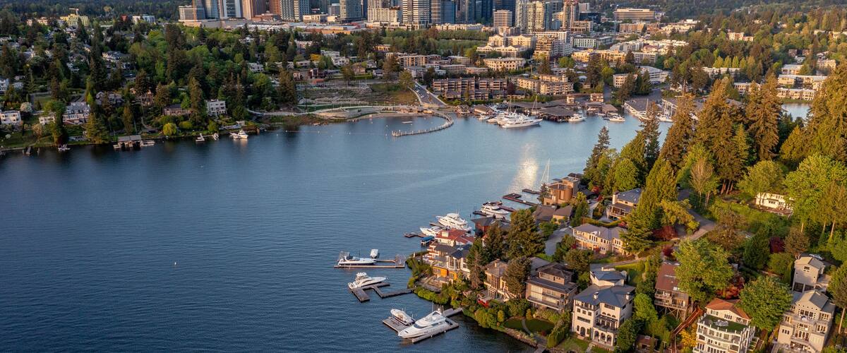 A waterfront cityscape with a marina, residential buildings, and a skyline of high-rise buildings.