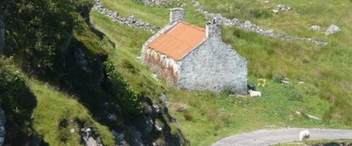 Derelict cottage at Culkein Drumbeg The jetty and Oldany Island in the distance.