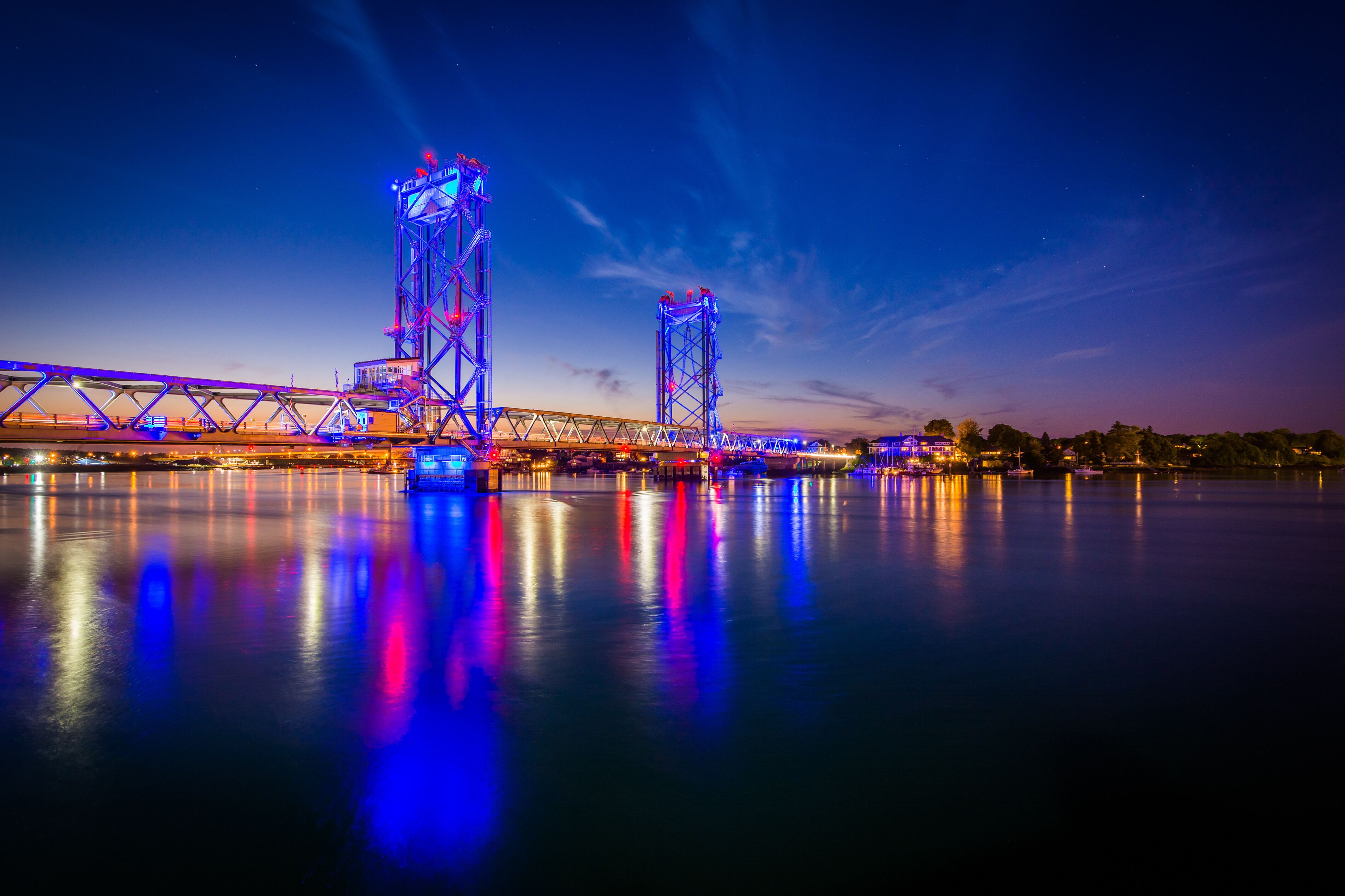 A bridge with illuminated structures at dusk.