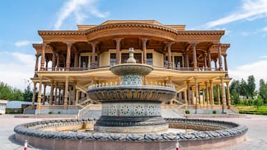 A large, ornate building with a central fountain and a circular stone platform.