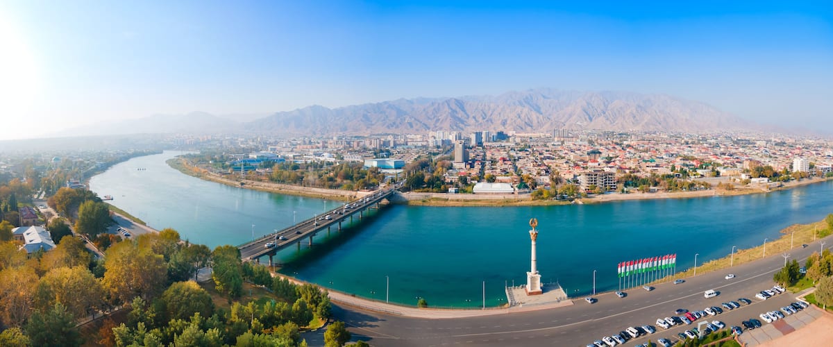 A river flowing through a city with mountains in the background.