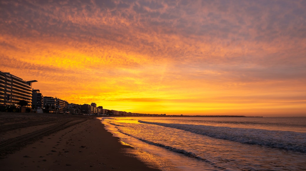 Amazing view of a fiery sunrise with multicolored clouds. Sea waves along the seashore at sunrise. Morning time. Ocean view. La Baule-Escoublac, France