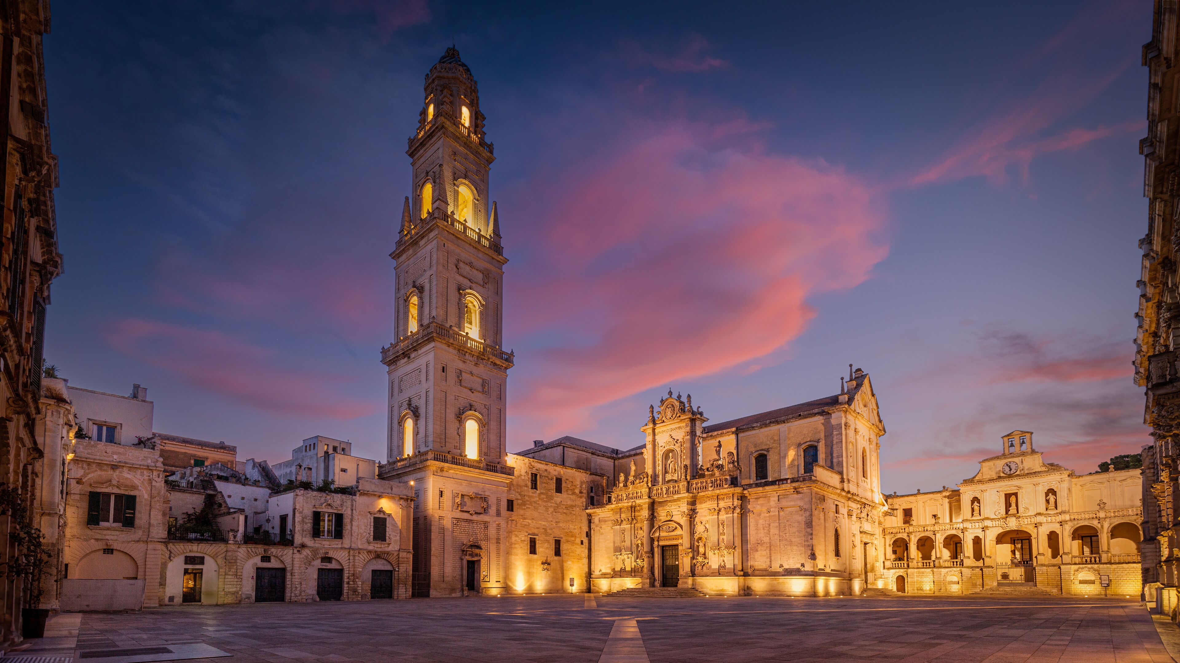A historic square with a prominent clock tower and ornate buildings.