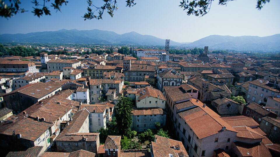 A densely packed urban area with historic buildings and a prominent tower in the distance.