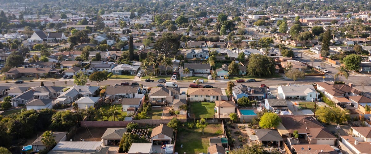 A suburban neighborhood with houses, trees, and a swimming pool.