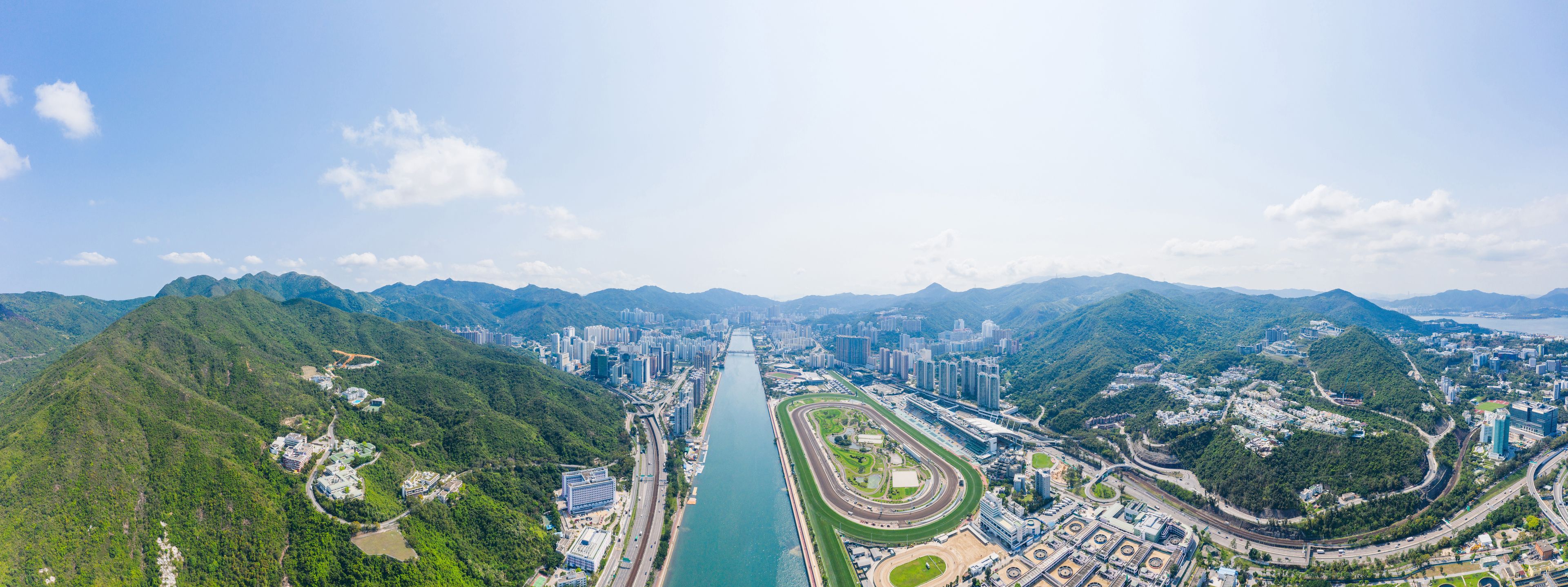 A cityscape with a river running through it, surrounded by mountains.
