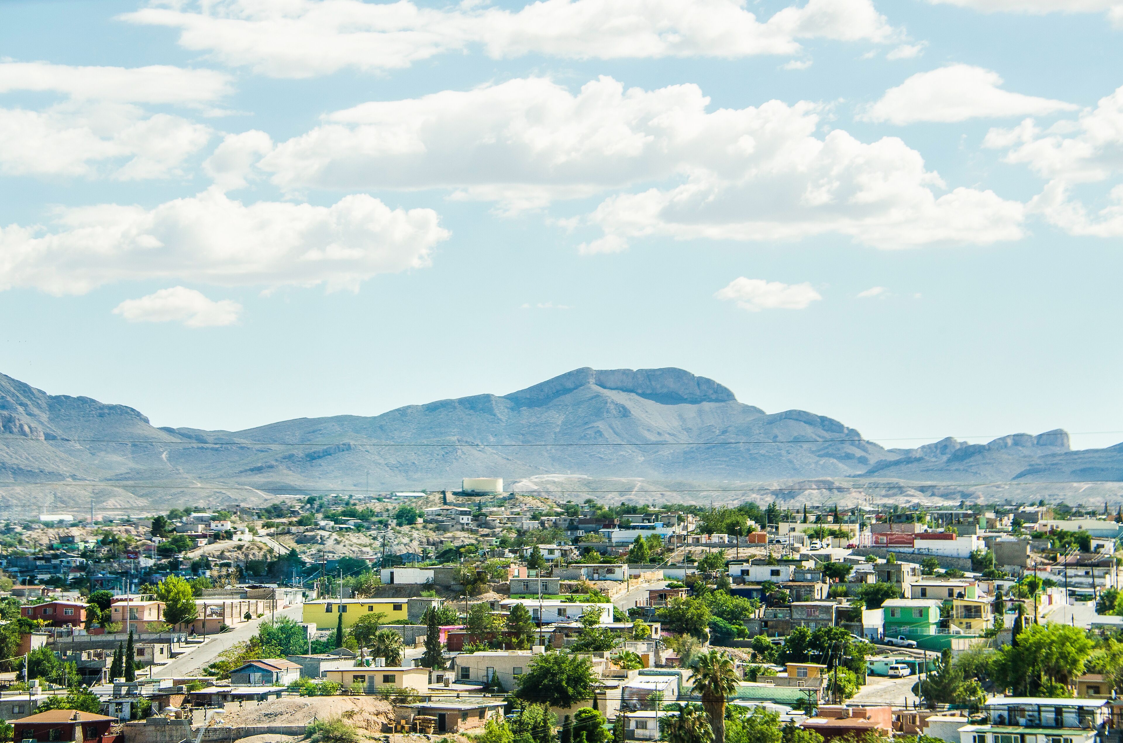 A town with colorful buildings, a mountain in the background, and a clear sky.