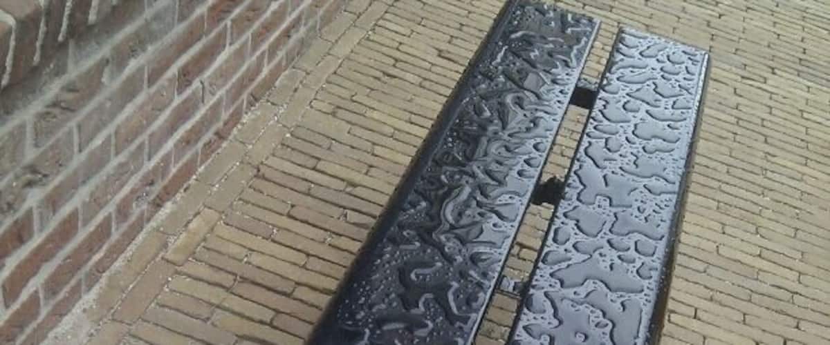 In between this fake buildings, the waterpatterns on an iron bench suddenly are of utmost beauty