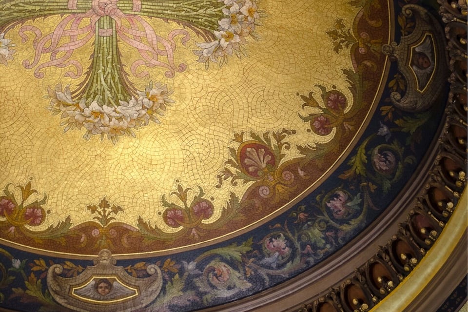 A detailed mosaic with a central floral design and an angelic figure.
