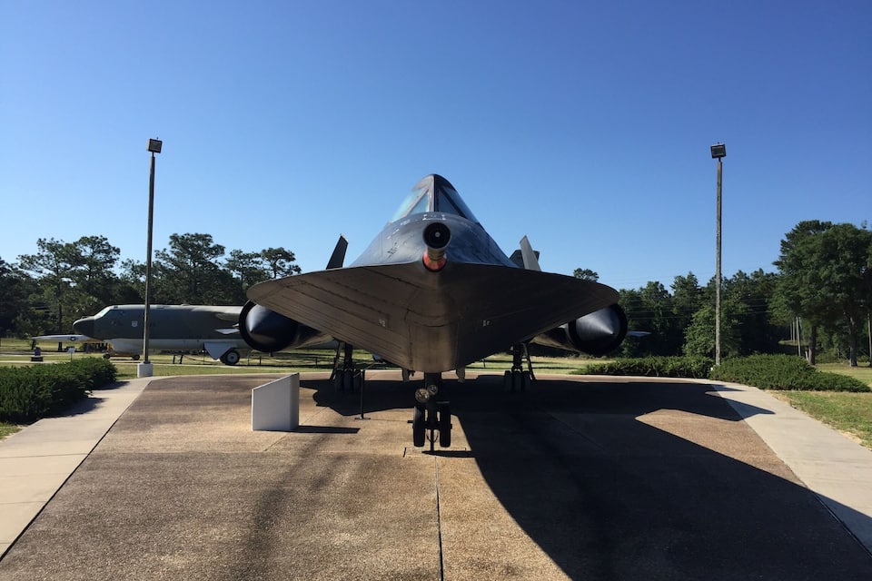 A military aircraft on display with a clear sky in the background.