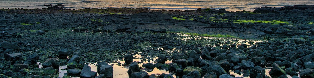 Sunset with Biyangdo island in a cloudy day, view from Hyeopjae beach in Aewol in Jeju Island, Korea.