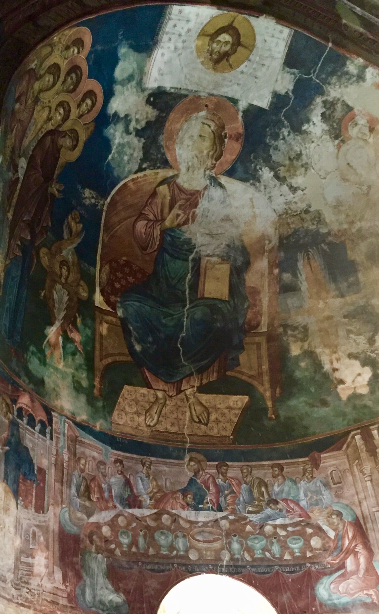 A fresco with a central figure in blue robes, surrounded by smaller figures and decorative elements.