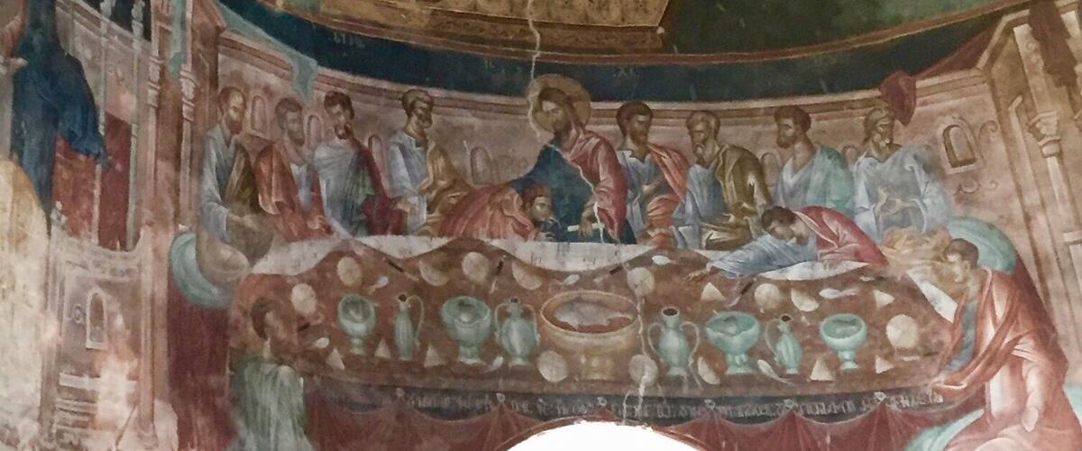 A fresco with a central figure in blue robes, surrounded by smaller figures and decorative elements.