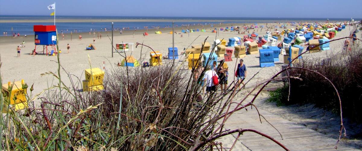 A beach with colorful beach huts and a lifeguard tower.